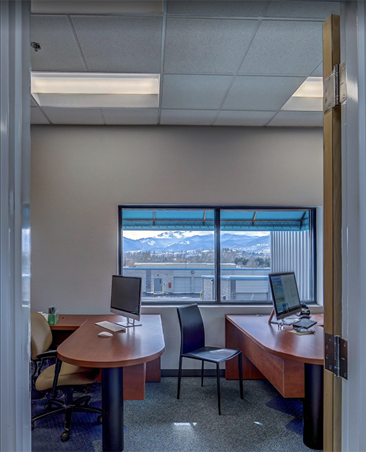 Looking into one of the offices in the administration building snowcapped mountains can be seen through the windows